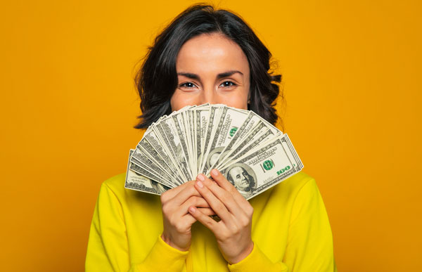 Young woman holding cash from a personal loan Brownsville